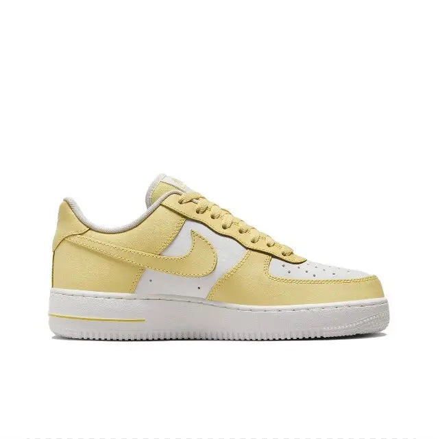 Nike low-top sneaker side view, pale yellow and white with gold swoosh