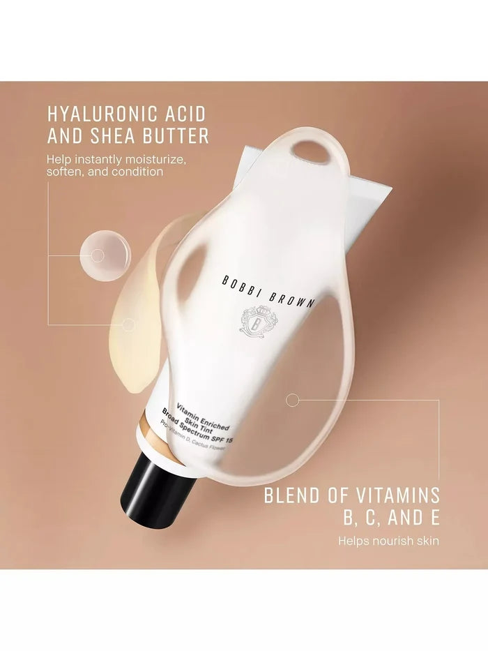 Tube of Bobbi Brown Skin Tint SPF 15 moisturizer with text highlighting hyaluronic acid, shea butter, and vitamins B, C, and E on a beige background.