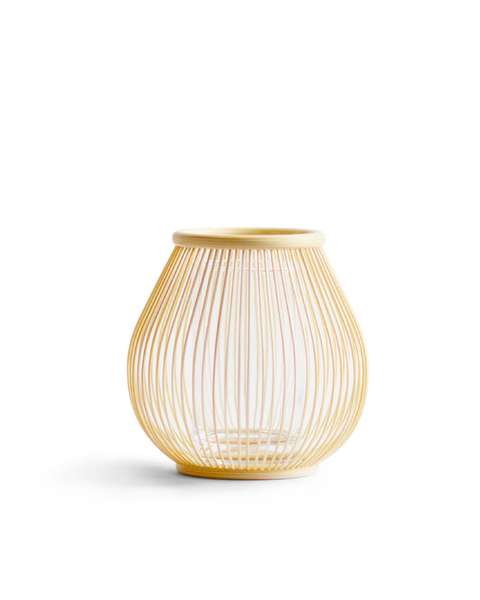 Round flower basket made out of thin natural bamboo strips against a white background.