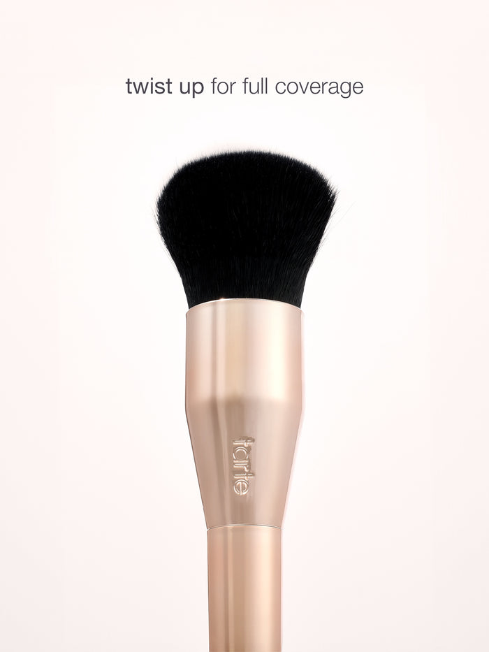 Makeup brush with black bristle head and rose gold handle on a white background