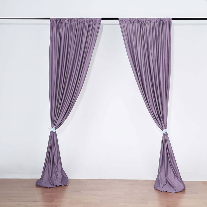 Purple curtains elegantly draped on a curtain rod against a white background.