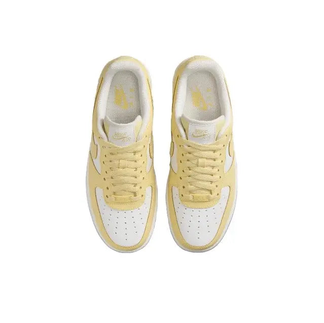 Nike low-top sneakers top view, pale yellow and white uppers with lace eyelets