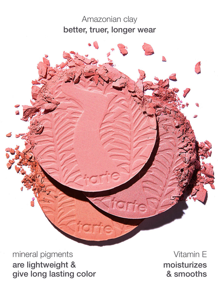 Three Tarte Cosmetics blush pans, embossed with leaf patterns, are scattered with pink powder on a white background. Text highlights Amazonian clay: better, truer, longer wear, mineral pigments: are lightweight & give long lasting color, and Vitamin E: moisturizes & smooths.