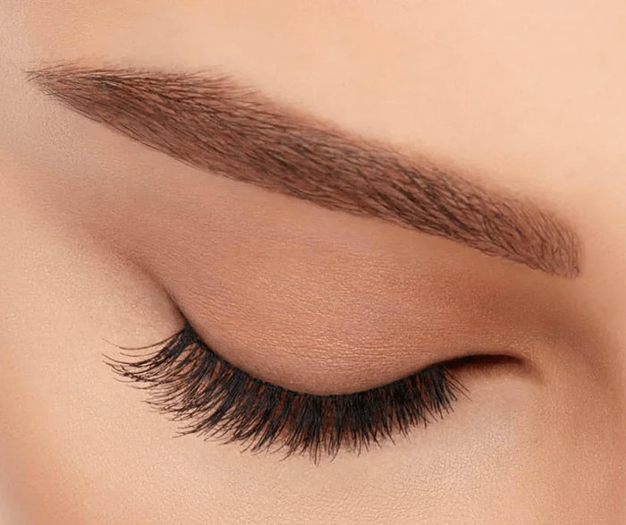 Close-up of closed eye with natural-looking, light volume, short length false eyelashes applied