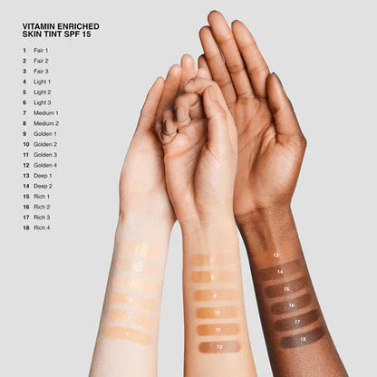 Three arms with various skin tint swatches, labeled by shade for vitamin enriched tint with SPF 15.