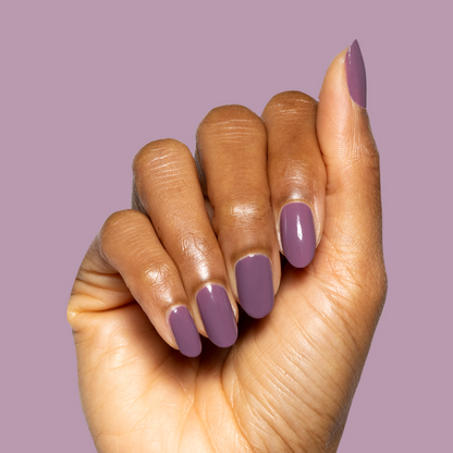 Hand with smooth quick-dry gel polish manicure in Cardigan’s warm mauve shade against matching mauve background