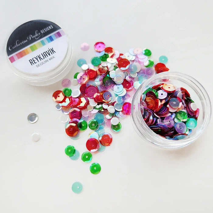 Catherine Pooler - Sequin Mix - Reykjavik. Reykjavík Sequin Mix adds a touch of playful elegance to your holiday projects. This iridescent mix features vibrant red and green sequins with soft pops of pink and icy blue. Available at Embellish Away located in Bowmanville Ontario Canada.