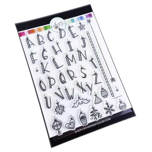 Catherine Pooler - Stamp Set - Dangling Alphabet. A floating alphabet that will hang from your page with the included bar lines. All twenty-six (26) letters are included along with icons for holidays and seasons throughout the year. Available at Embellish Away located in Bowmanville Ontario Canada.