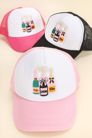 A sparkling mess champagne trucker hat with embroidered champagne bottle and logo, casual accessory for style and sun protection.