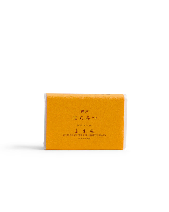 Kobe Honey Mutenka Sekken soap against a white backdrop. Packaging in orange in color.