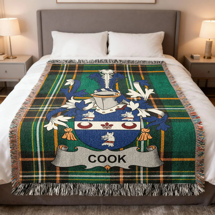 Cook family crest woven blanket spread over a bed.