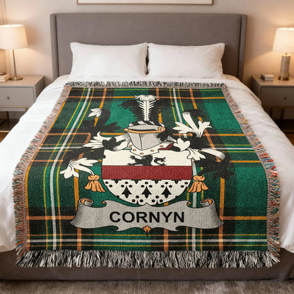 Cornyn family crest woven blanket folded at the end of a bed.