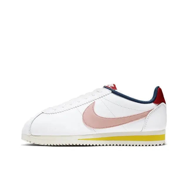 Nike Cortez low-top sneakers, white with pink swoosh, navy trim, red heel, yellow sole