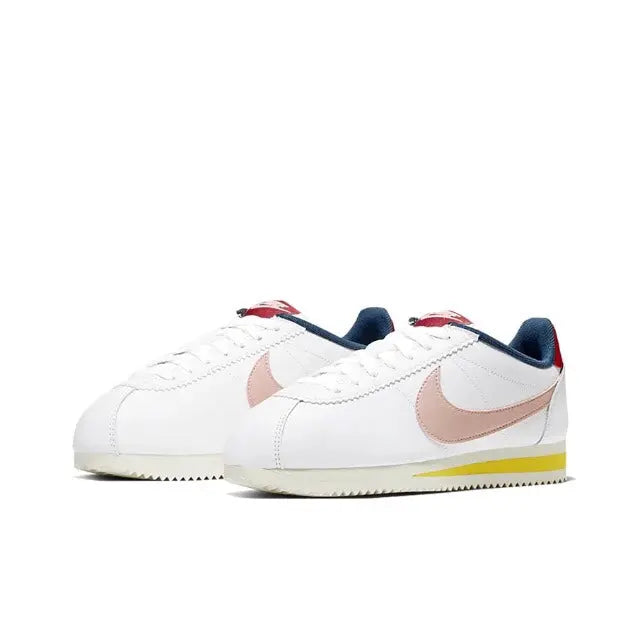 Nike Cortez low-top sneakers pair, white uppers with pink swooshes, navy lace loops