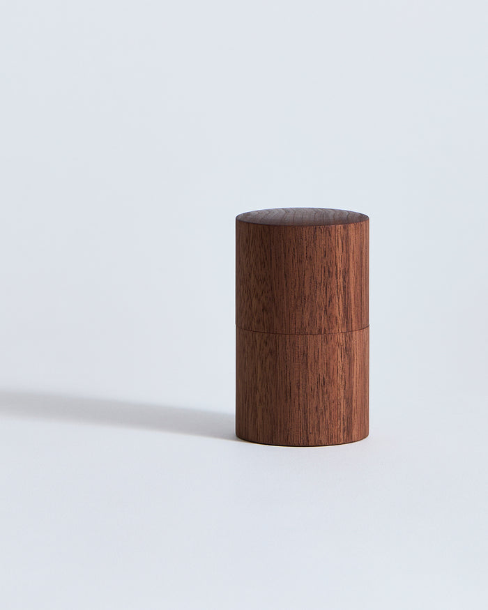 Wooden cylindrical container by Ryuiji Mitani on a light gray background
