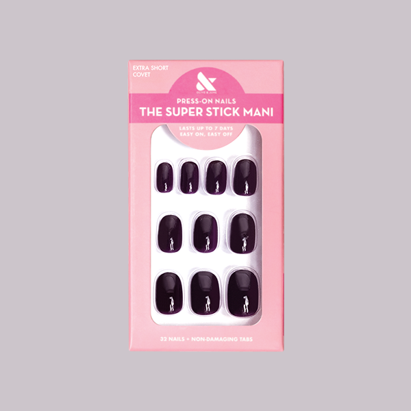 Covet | Extra Short | Round - Tab Press-On nails in deep plum shade with glossy finish displayed in pink packaging