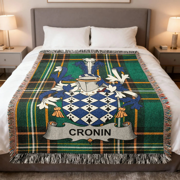 Cronin family crest woven blanket laid across a bed.