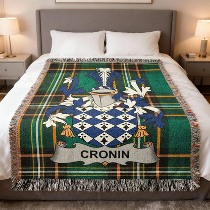 Cronin family crest woven blanket laid across a bed.