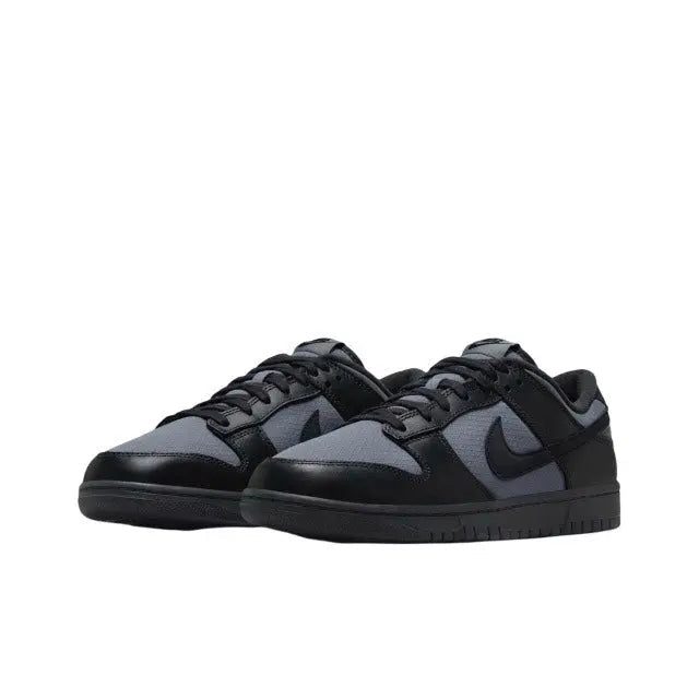 Low-top sneaker with black laces and gray panels, dark navy upper with swoosh