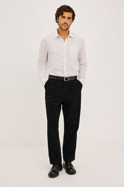 Ezra Pant in Brushed Cotton Twill With Relaxed Fit, Single Front Pleats, Ankle-Length Hem, Zip Fly, Side Pockets, and Back Double-Welt Pockets in Black Colorway - Full Body Front View Featured on Model