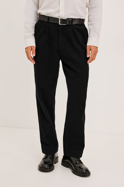 Ezra Pant in Brushed Cotton Twill With Relaxed Fit, Single Front Pleats, Ankle-Length Hem, Zip Fly, Side Pockets, and Back Double-Welt Pockets in Black Colorway - Full Body Front View Featured on Model