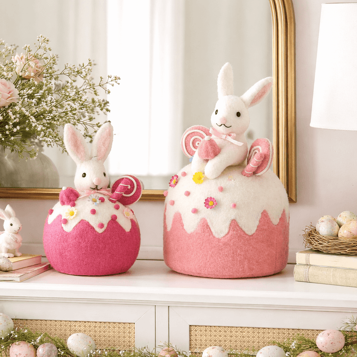 Decorative Easter mantel with pink bunny jars, flowers, and a lamp.