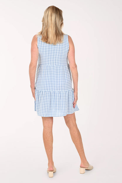 Woman wearing a sleeveless gingham blue dress