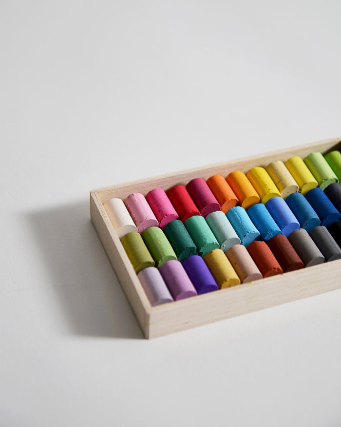 Close up of box of colorful pastels by Ohkan Kagaku Kogyosyo on a gray background