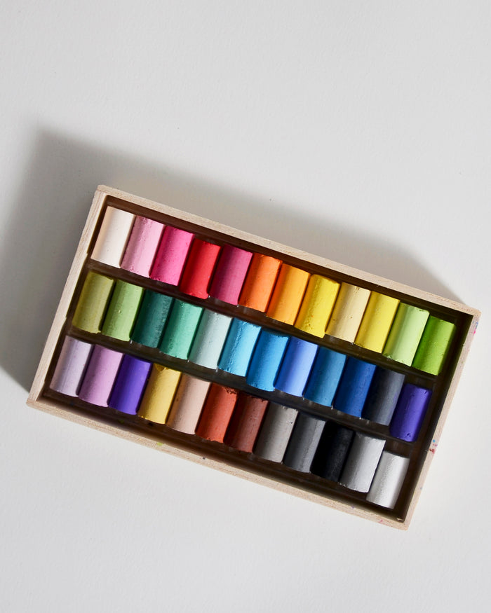 Box of colorful pastels by Ohkan Kagaku Kogyosyo on a gray background