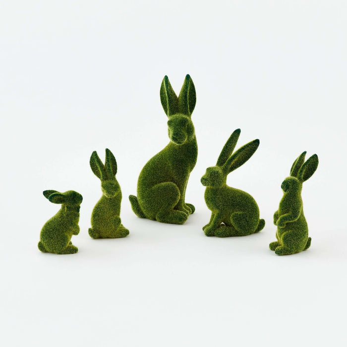 Set of green rabbit figurines on a white background