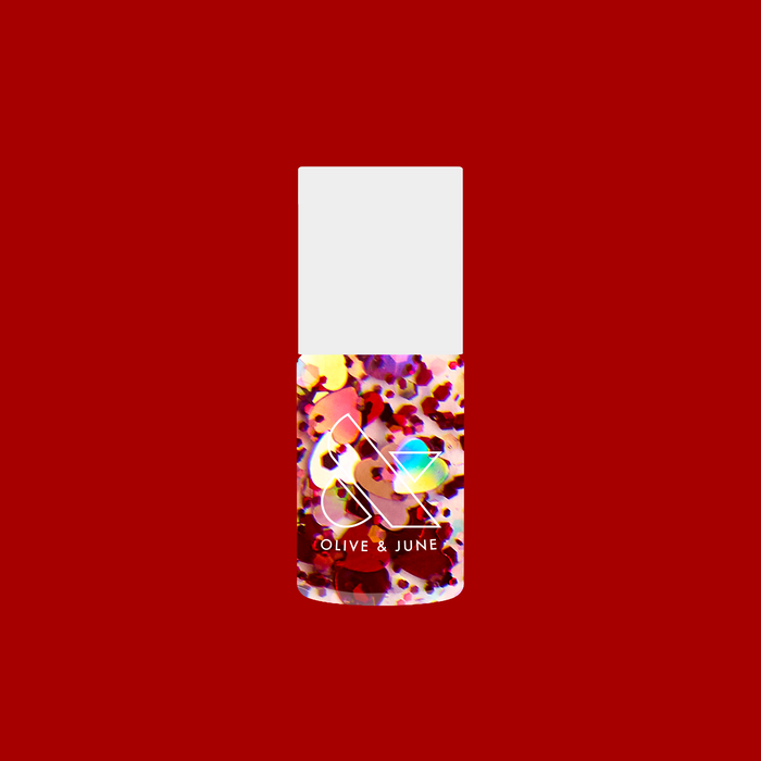Bottle of HEARTED quick dry polish filled with heart and sequin confetti by Olive and June on a solid red background