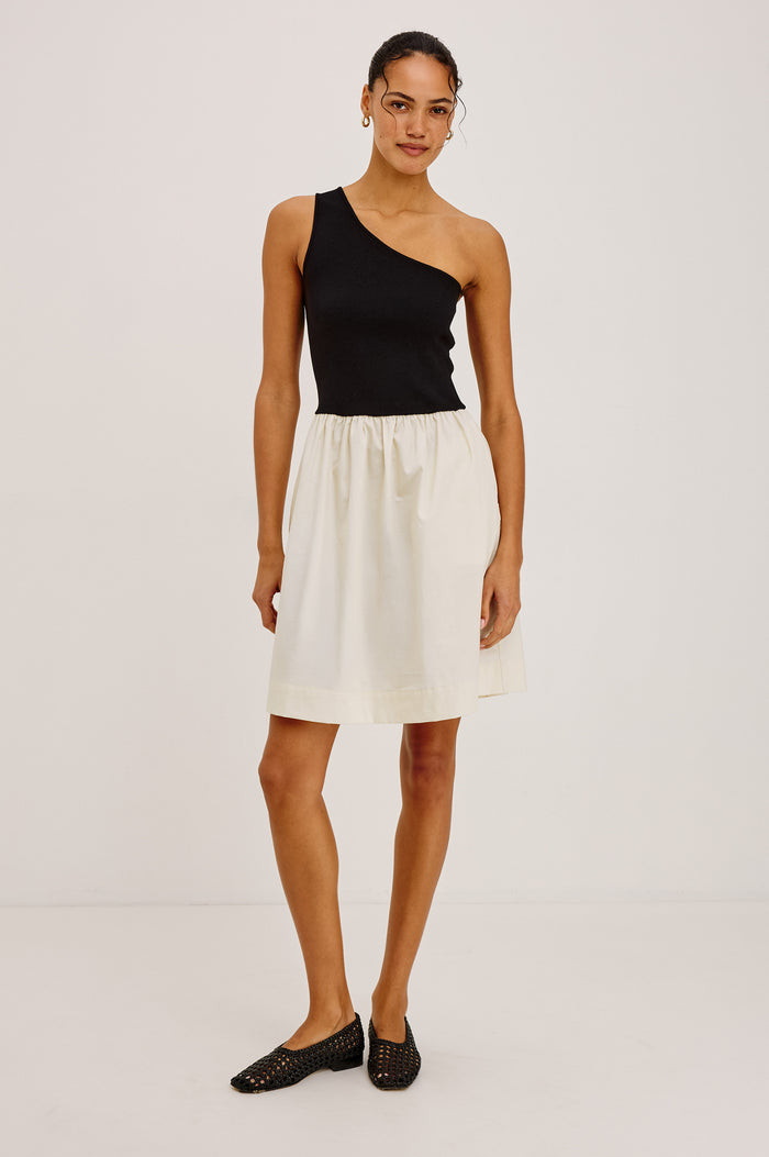 Joanne Mini Dress With One-Shoulder Neckline, Soft Jersey Bodice, Contrast Dropwaist Cotton Poplin Skirt, and Side Pockets in Black Ivory Colorway - Full Body Front View Featured on Model
