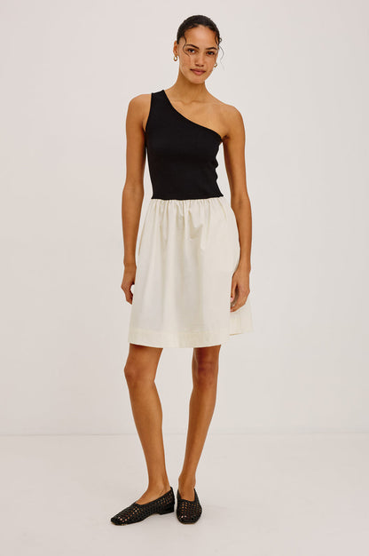 Joanne Mini Dress With One-Shoulder Neckline, Soft Jersey Bodice, Contrast Dropwaist Cotton Poplin Skirt, and Side Pockets in Black Ivory Colorway - Full Body Front View Featured on Model