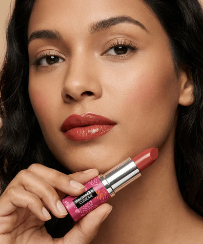 Woman holding Marimekko x Clinique red lipstick, wearing matching bold lip color