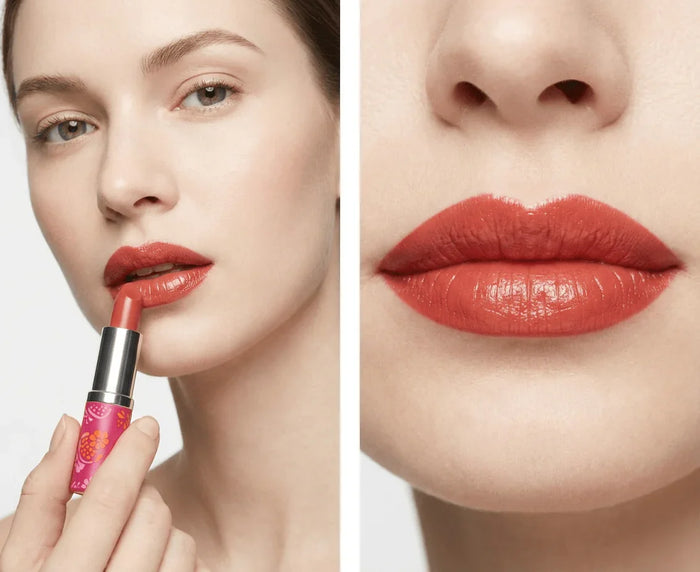 Woman applying red lipstick, close-up of lips with poppy red creamy lip color