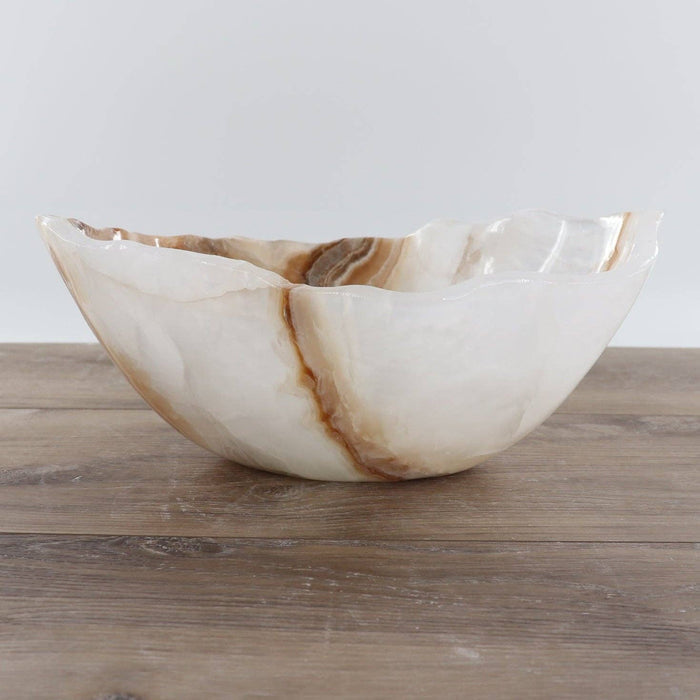 Mexican Onyx/Calcite Bowl 12" featuring warm amber tones and hand-carved design on wooden surface.