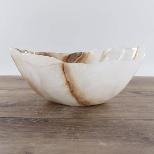 Mexican Onyx/Calcite Bowl 12" featuring warm amber tones and hand-carved design on wooden surface.