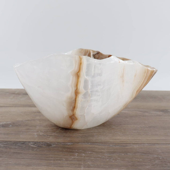Mexican Onyx/Calcite Bowl 12" showcasing unique amber banding and organic shape on wooden surface.