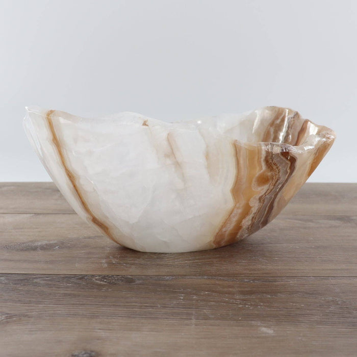 Mexican Onyx/Calcite Bowl 12" displayed on a wooden surface, showcasing its unique banding and hand-carved details.