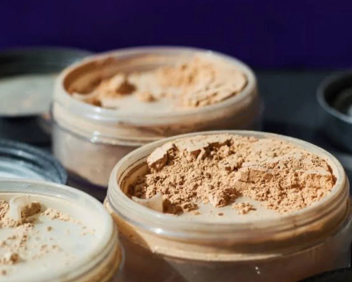 Mineral powder foundation in open jars, medium skin tone makeup shades