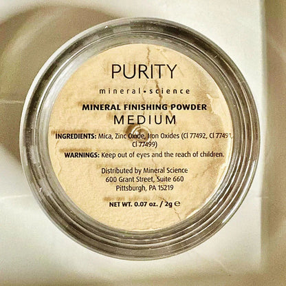 Mineral finishing powder in medium shade, clear round container with product label visible