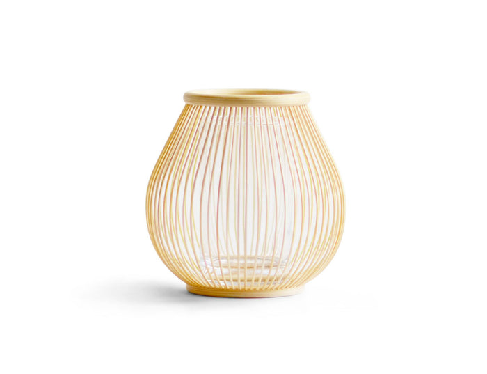 Round flower basket made out of thin natural bamboo strips against a white background.