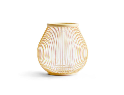 Round flower basket made out of thin natural bamboo strips against a white background.