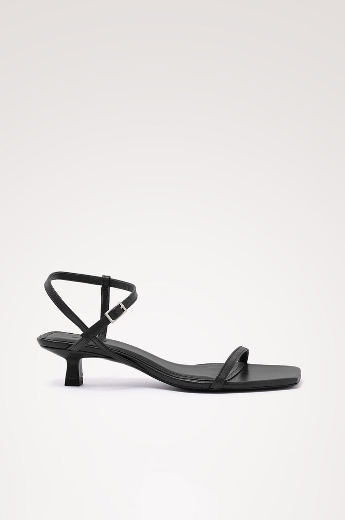 Palma Sandal Heel in Top-Grain Leather With Single Toe Strap, Adjustable Buckled Wrap Ankle Strap, and Low Heel in Black Colorway - side view of shoe.