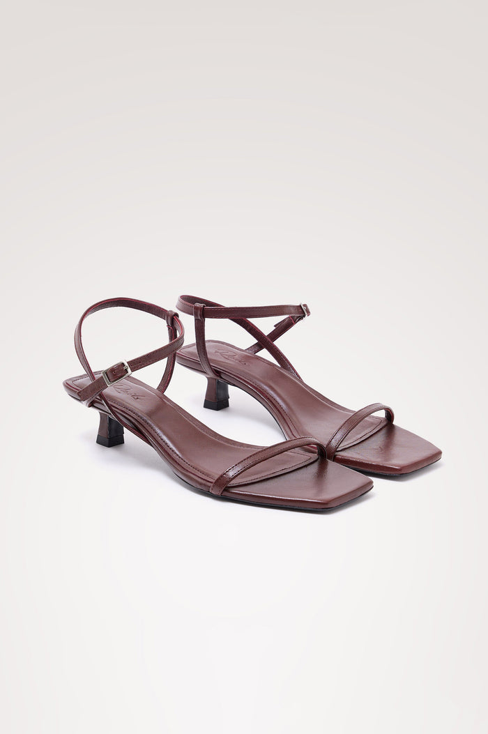 Palma Sandal Heel in Top-Grain Leather With Single Toe Strap, Adjustable Buckled Wrap Ankle Strap, and Low Heel in Burgundy Colorway - angeled frontview of shoe.