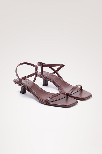 Palma Sandal Heel in Top-Grain Leather With Single Toe Strap, Adjustable Buckled Wrap Ankle Strap, and Low Heel in Burgundy Colorway - angeled frontview of shoe.