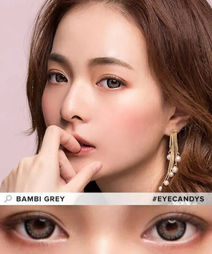 Asian model showcasing Bambi Grey contact lenses while gesturing with her index finger near her lips, close-up of eyes enhanced by grey contacts