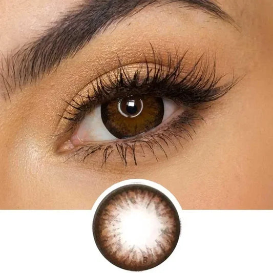 Pink Label Grang Big choco color contact lens on top of a dark eye paired with subtle eye makeup and curled wispy eyelashes, above the contact lens design.
