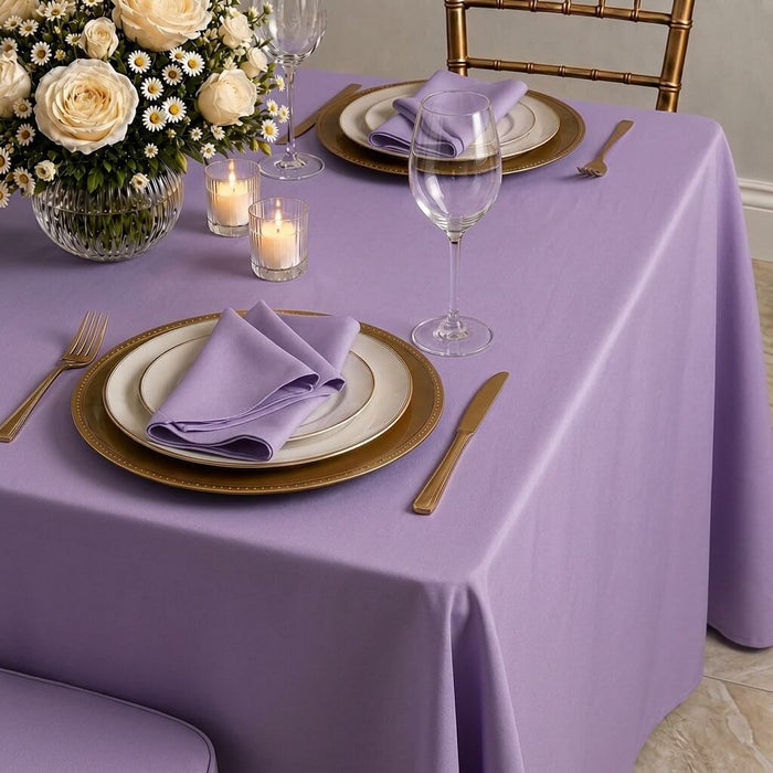 Violet amethyst tablecloth on a dining table set with flowers and dinnerware.