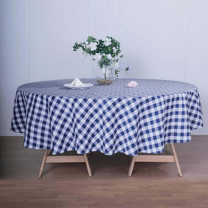 Navy and white gingham tablecloth draped over a round table with floral centerpiece.